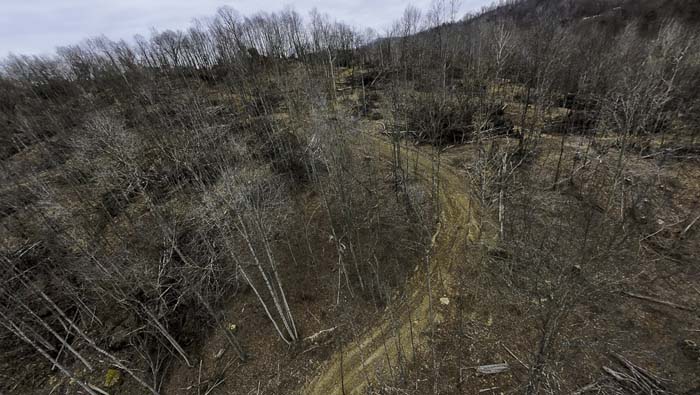 Land with cave area and wooded hillside