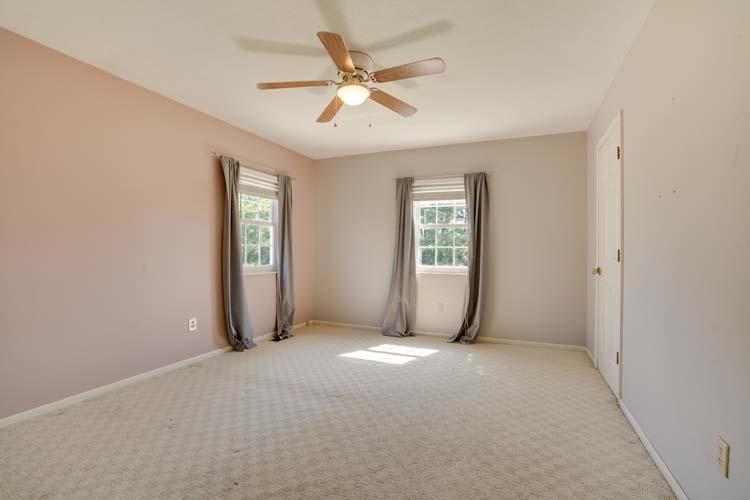 Bedroom with neutral tones and large windows